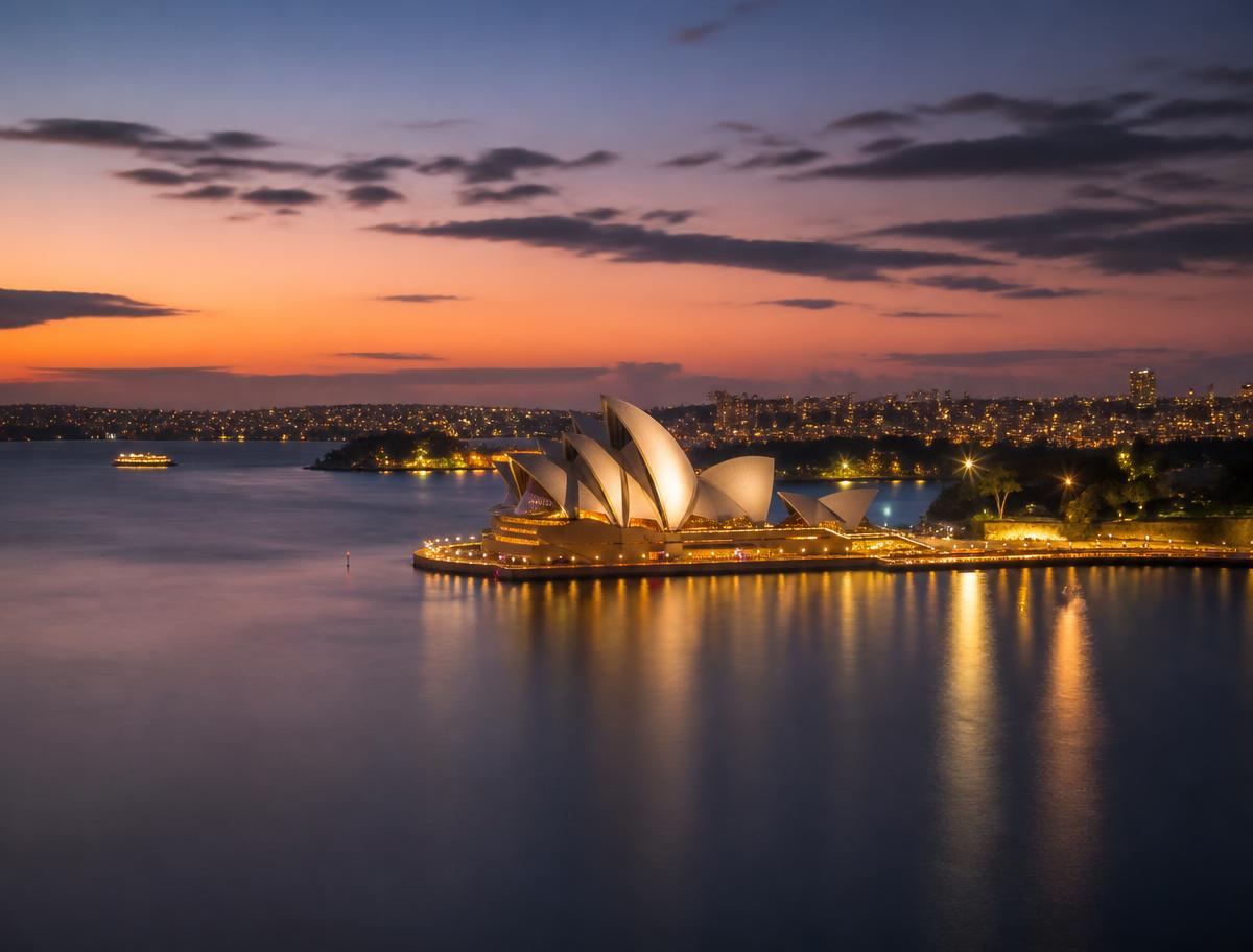 Sydney Harbour at dusk with city lights reflected on the water